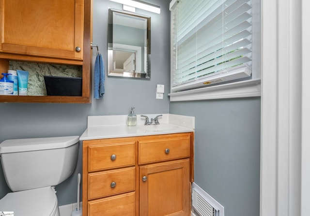 bathroom featuring toilet, visible vents, and vanity
