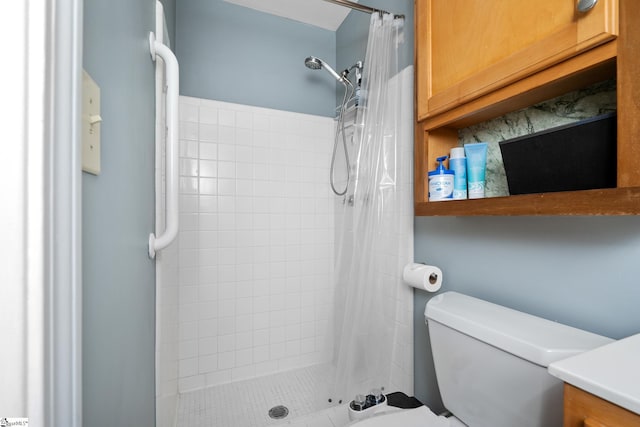 bathroom with a shower stall and toilet