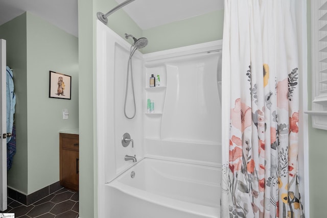 bathroom with tile patterned floors, baseboards, and shower / tub combo with curtain