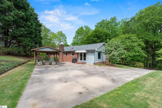 ranch-style home with a front lawn, a chimney, and brick siding