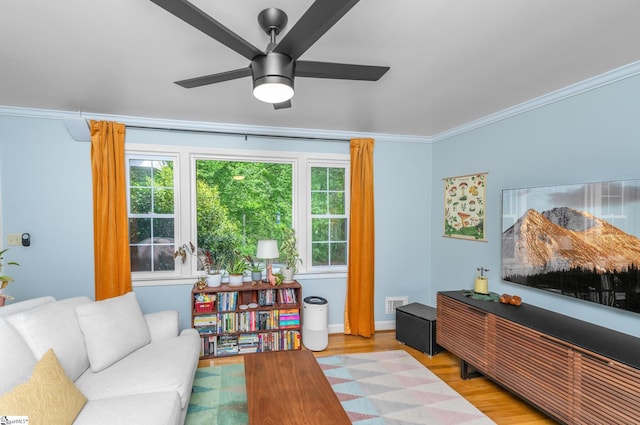 living area with ornamental molding, a ceiling fan, visible vents, and wood finished floors