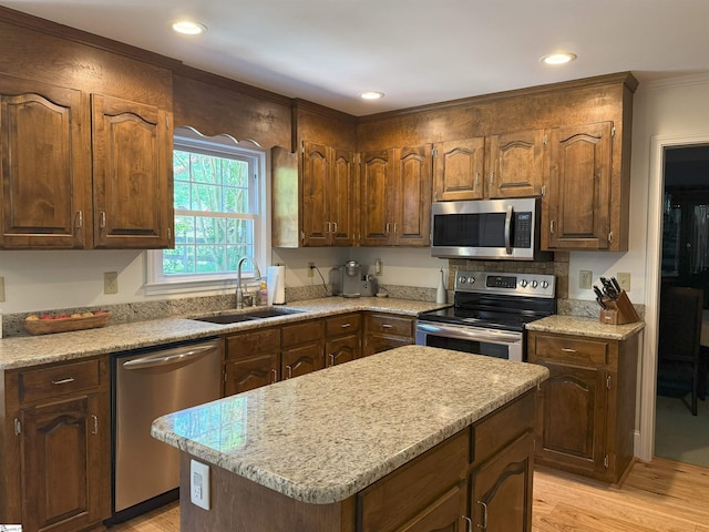 kitchen with light wood-style flooring, a sink, appliances with stainless steel finishes, and light countertops