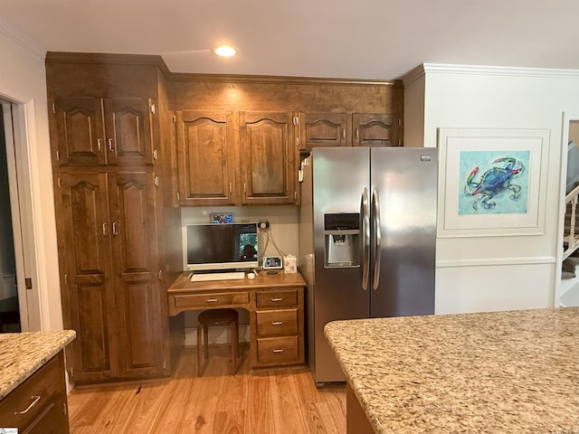 kitchen featuring light wood-style flooring, light stone countertops, ornamental molding, recessed lighting, and stainless steel fridge