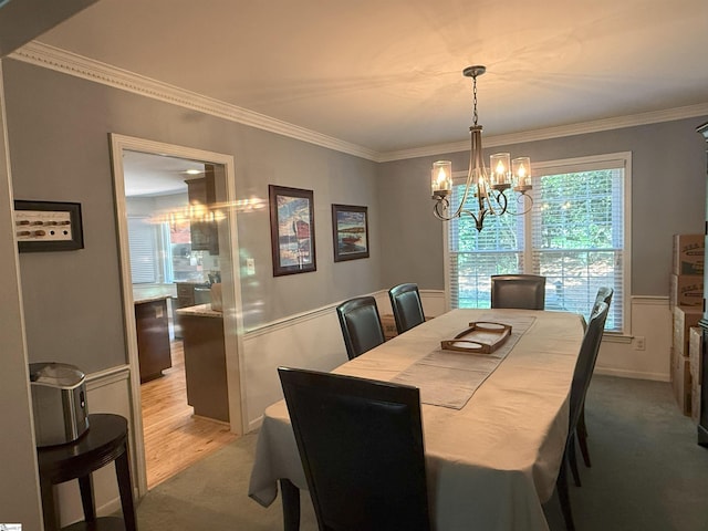 dining room with ornamental molding, light carpet, and a chandelier