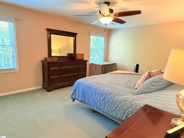 bedroom with ceiling fan, baseboards, carpet flooring, and multiple windows