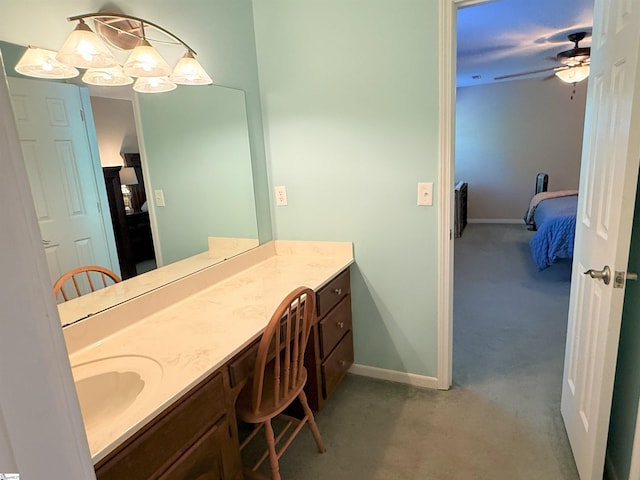 ensuite bathroom featuring ensuite bathroom, ceiling fan, vanity, and baseboards
