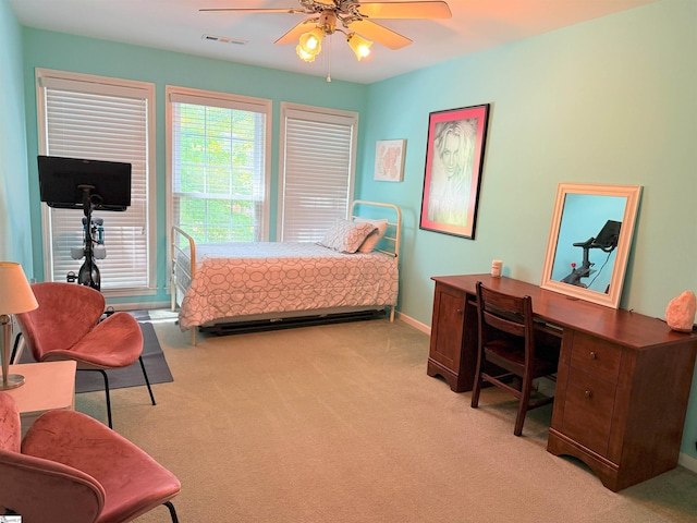 bedroom with a ceiling fan, visible vents, light carpet, and baseboards