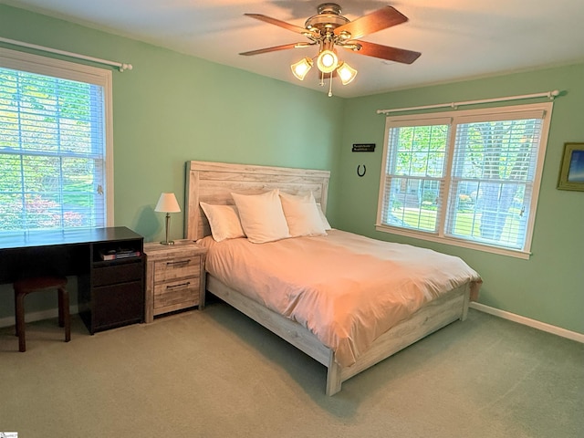 bedroom with light colored carpet, a ceiling fan, and baseboards