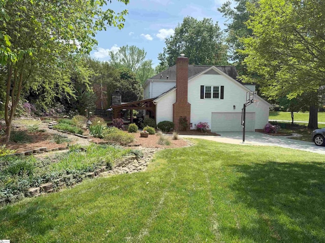 view of home's exterior featuring concrete driveway, a lawn, a garage, and a chimney