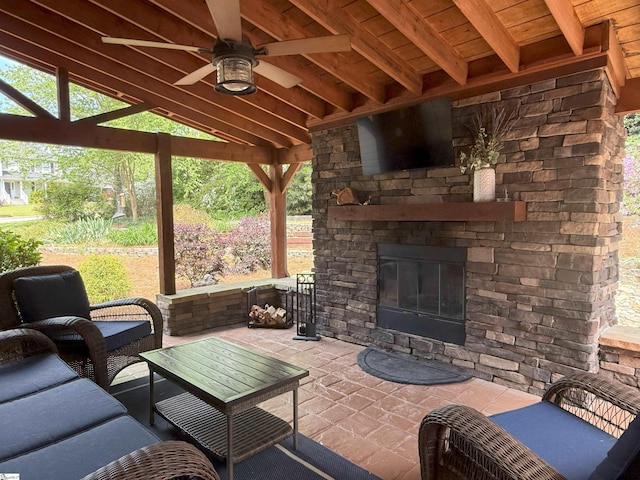 view of patio / terrace with ceiling fan and an outdoor living space with a fireplace
