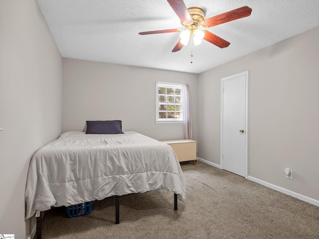 carpeted bedroom featuring a textured ceiling, ceiling fan, and baseboards