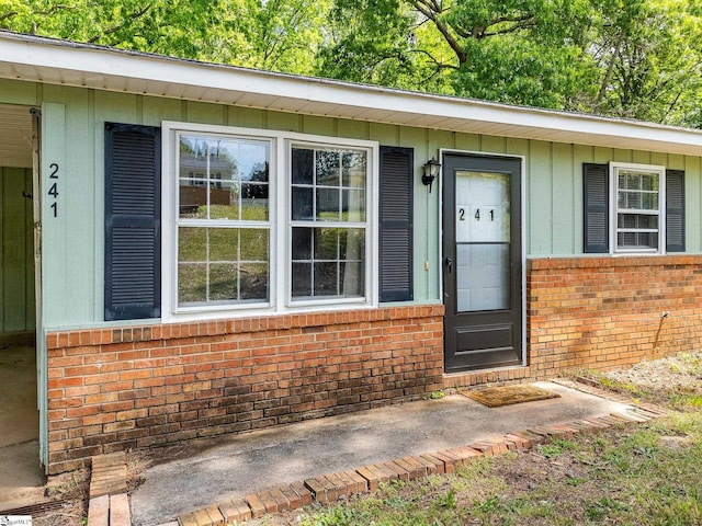 doorway to property with brick siding