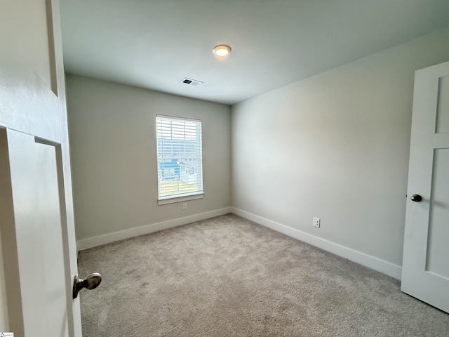 spare room featuring visible vents, carpet, and baseboards