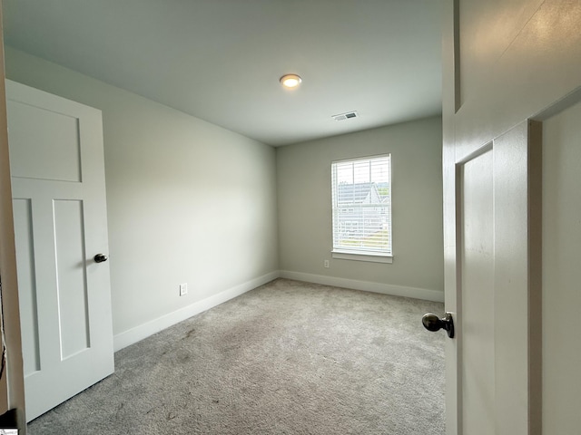 carpeted empty room featuring visible vents and baseboards
