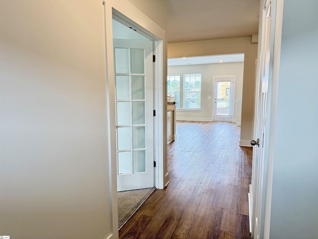 corridor with dark wood-style floors and baseboards