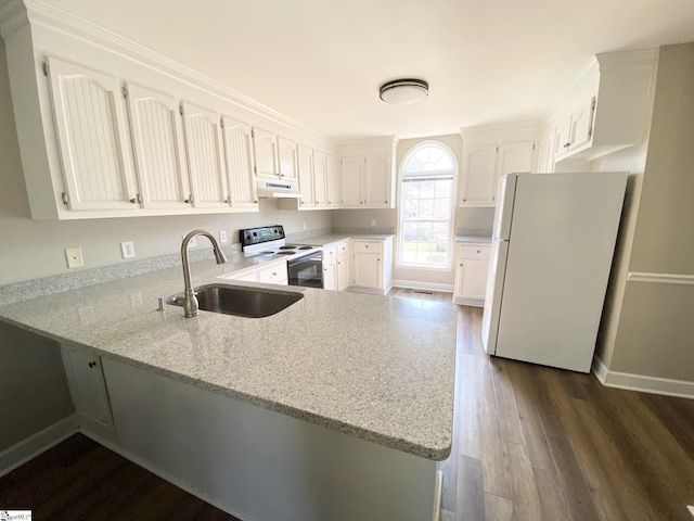 kitchen featuring white appliances, under cabinet range hood, a sink, a peninsula, and dark wood-type flooring