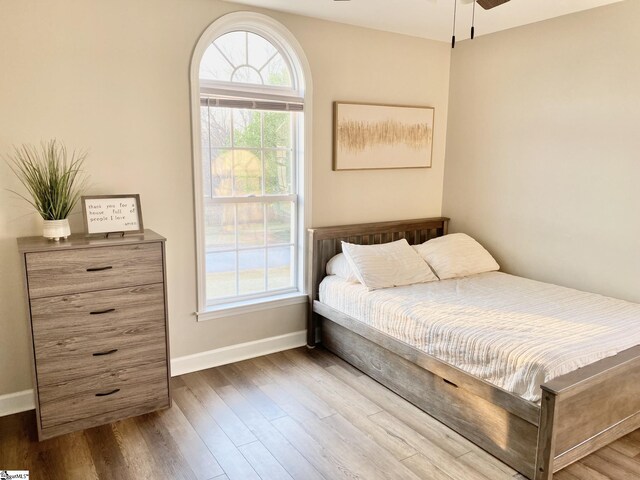 bedroom featuring wood finished floors and baseboards