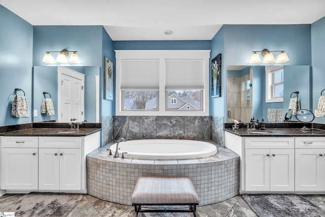 full bathroom featuring plenty of natural light, a bath, and a sink