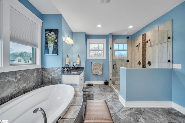 bathroom with vanity, a bath, a stall shower, marble finish floor, and baseboards