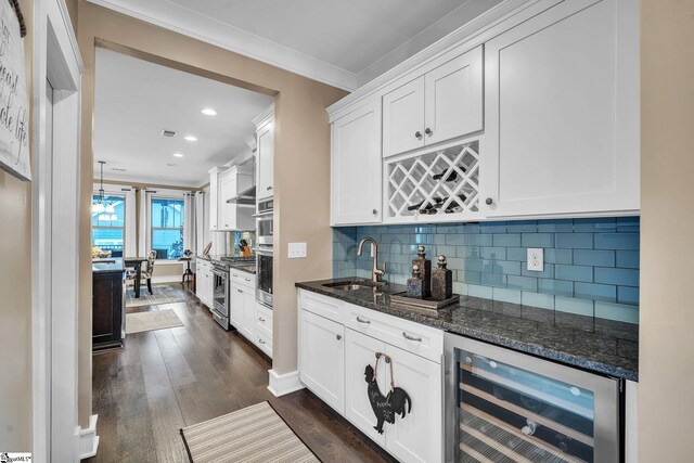 bar with beverage cooler, stainless steel appliances, ornamental molding, a sink, and wet bar
