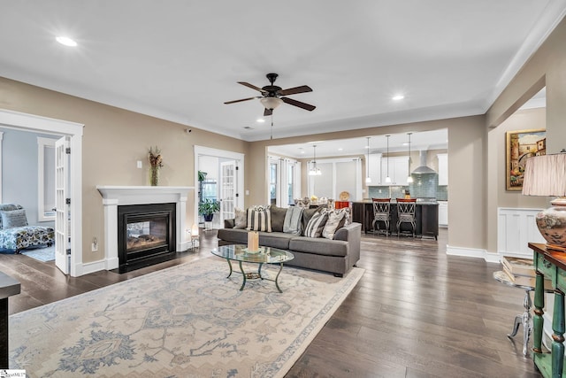 living room with recessed lighting, ceiling fan, dark wood-style flooring, and a fireplace with flush hearth