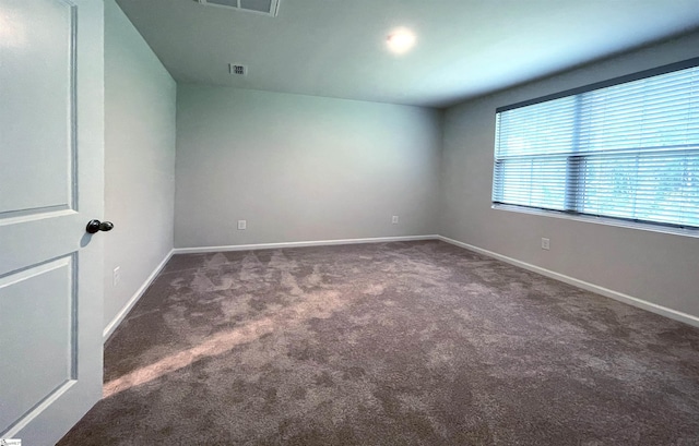 carpeted empty room with visible vents and baseboards