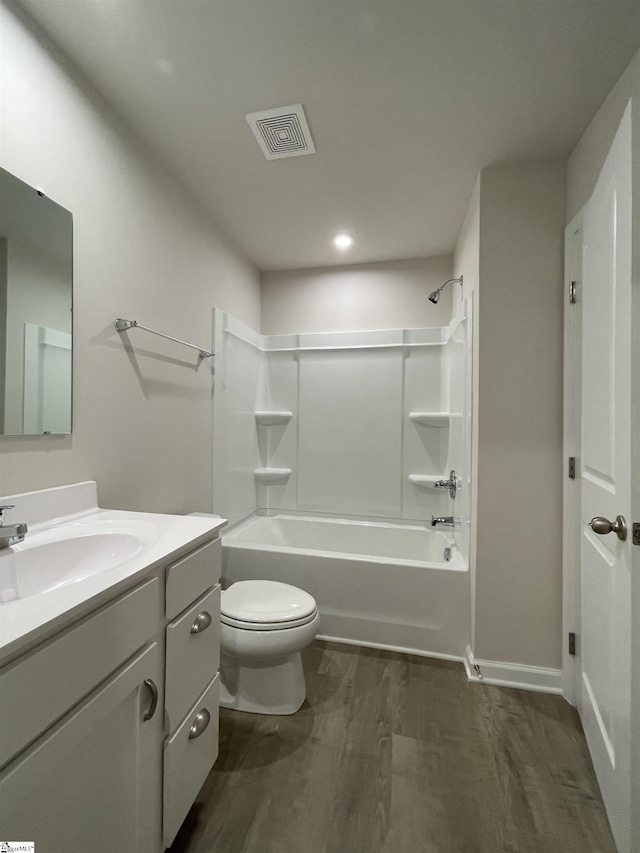 full bathroom featuring vanity, toilet, visible vents, bathtub / shower combination, and wood finished floors