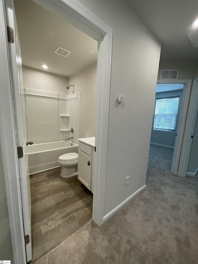 bathroom featuring visible vents, washtub / shower combination, toilet, and vanity