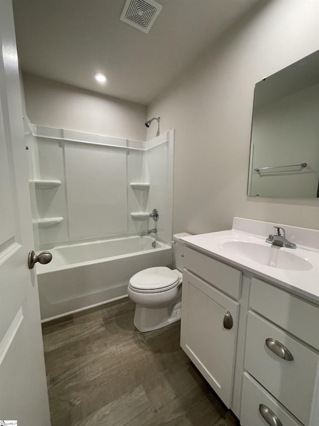 bathroom featuring wood finished floors, bathtub / shower combination, toilet, vanity, and visible vents
