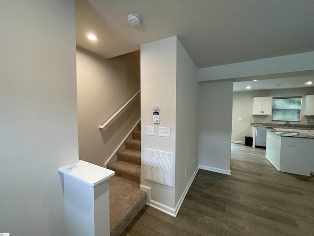 staircase featuring baseboards, visible vents, wood finished floors, and recessed lighting