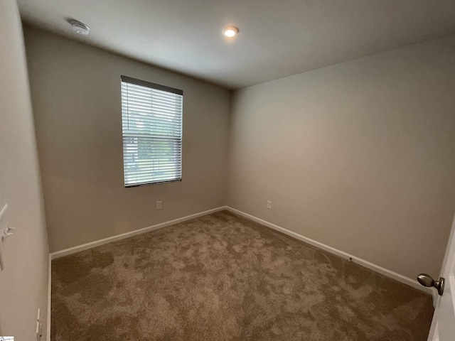 carpeted spare room with baseboards