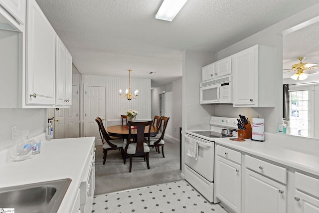 kitchen featuring white appliances, light countertops, a textured ceiling, white cabinets, and light floors