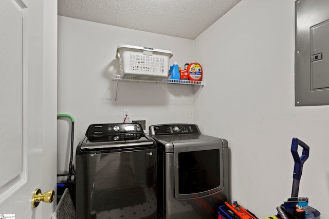 laundry room with washer and clothes dryer, a textured ceiling, electric panel, and laundry area