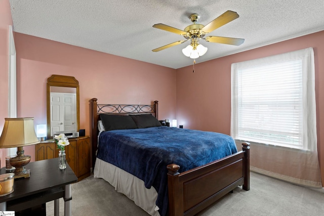 bedroom with a textured ceiling, multiple windows, light carpet, and baseboards