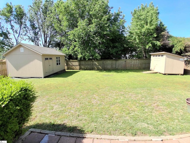 view of yard featuring an outbuilding, a shed, and a fenced backyard