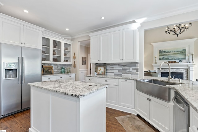 kitchen with a sink, white cabinetry, stainless steel appliances, and dark wood-type flooring