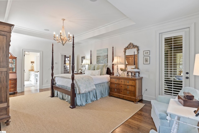bedroom featuring wood finished floors, a tray ceiling, a notable chandelier, and access to exterior