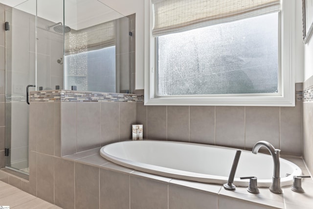 full bathroom featuring a shower stall and a bath