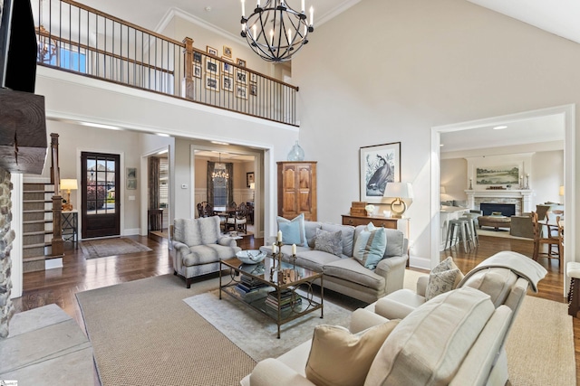 living room featuring a fireplace, a towering ceiling, and wood finished floors