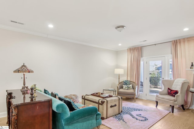 living area with crown molding, recessed lighting, visible vents, and light wood-style flooring