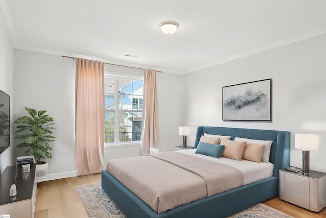 bedroom with visible vents, light wood-style floors, and crown molding