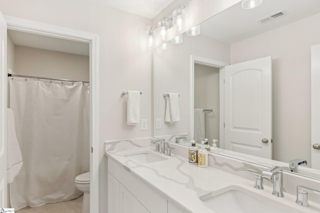 bathroom featuring tile patterned floors, visible vents, toilet, and a sink