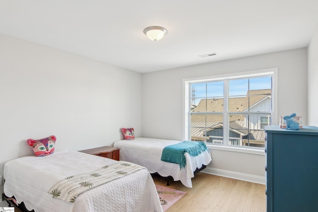 bedroom with visible vents, baseboards, and light wood-style floors
