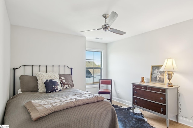 bedroom with baseboards, visible vents, wood finished floors, and ceiling fan