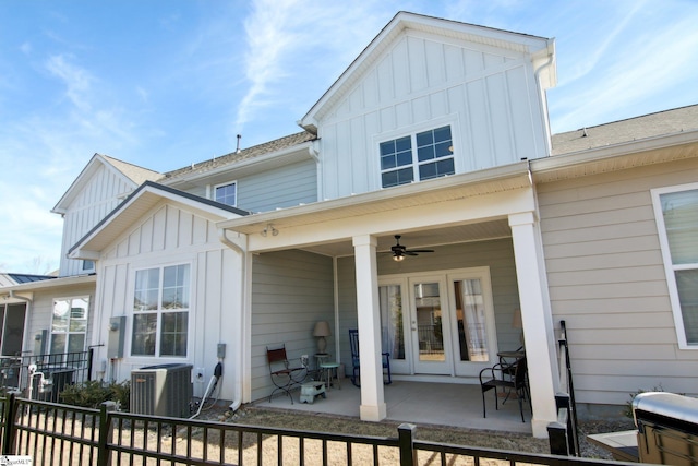 rear view of property with board and batten siding, ceiling fan, cooling unit, and a patio area