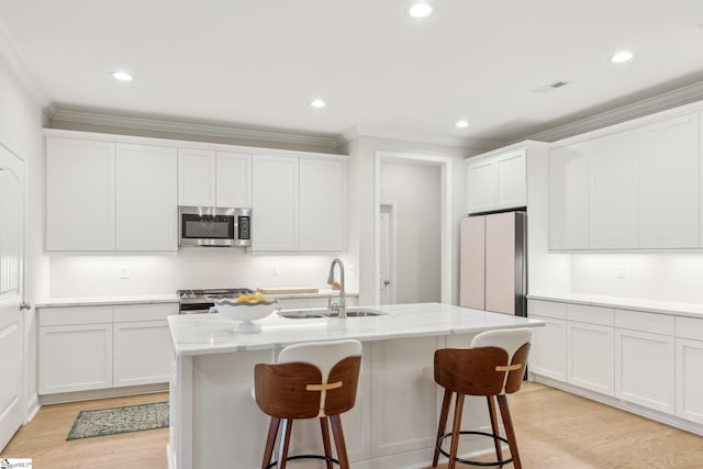 kitchen with crown molding, a kitchen bar, a sink, and stainless steel appliances