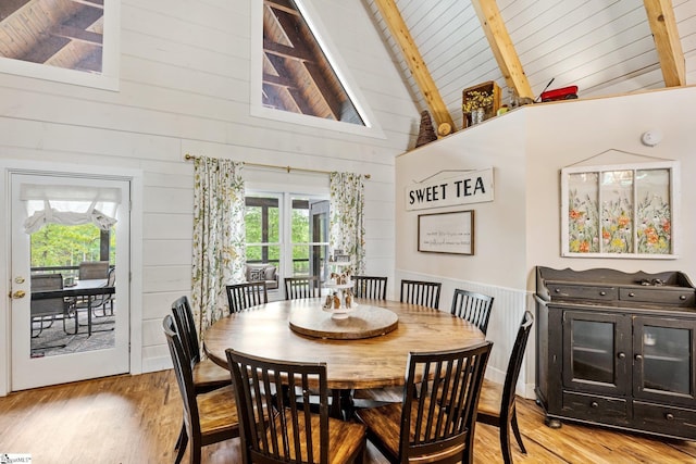 dining area featuring a wealth of natural light, high vaulted ceiling, light wood-style flooring, and beamed ceiling