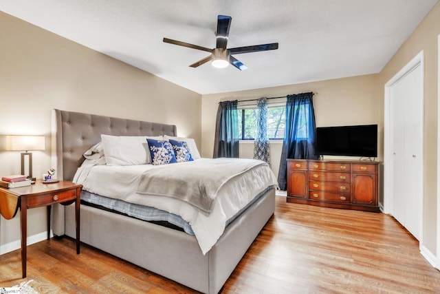 bedroom featuring ceiling fan, baseboards, and light wood-style floors