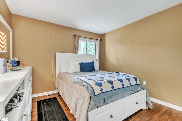 bedroom with wood finished floors and baseboards