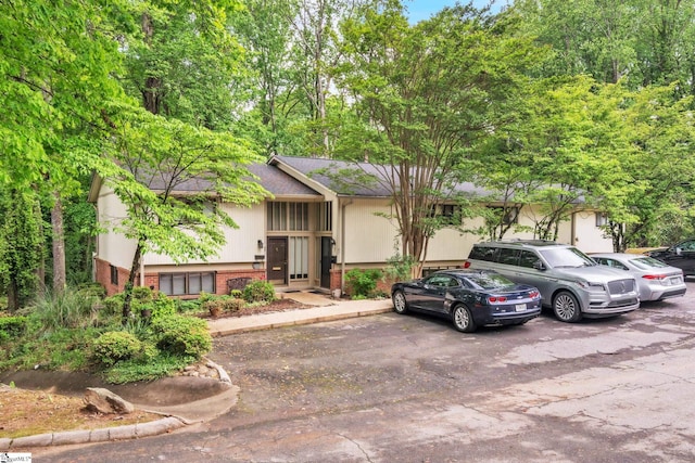 bi-level home featuring uncovered parking and brick siding